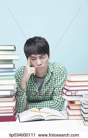 Stock Image - Studying man at the desk. Fotosearch