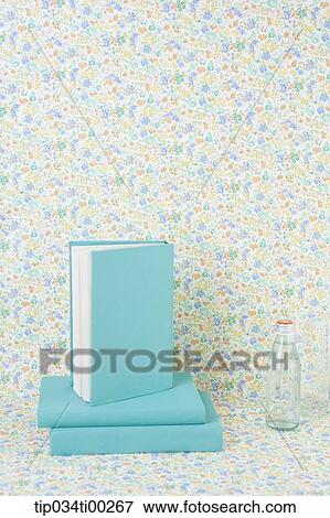 Stock Photo - The blue cover book and the glass bottle. Fotosearch