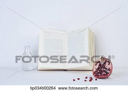 Picture - The book, glass bottle, and pomegranate . Fotosearch