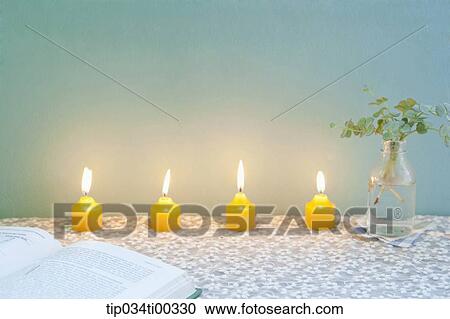 Stock Image - The book, lighting candle, and green plant in glass bottle. Fotosearch