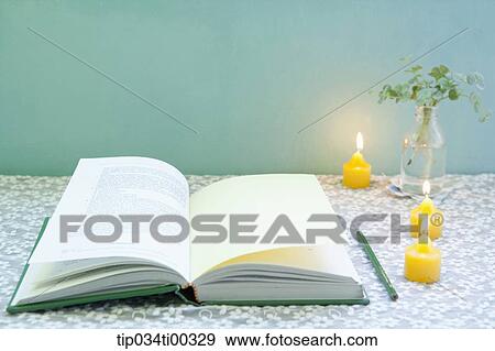 Stock Photo - The book, pencil, candle, and green plant in glass bottle. Fotosearch