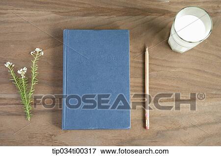 Stock Photo - The book with pencil, flower, a glass of milk around. Fotosearch