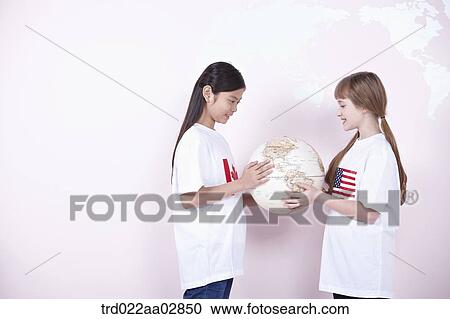 Stock Image - The global students looking at the globe. Fotosearch