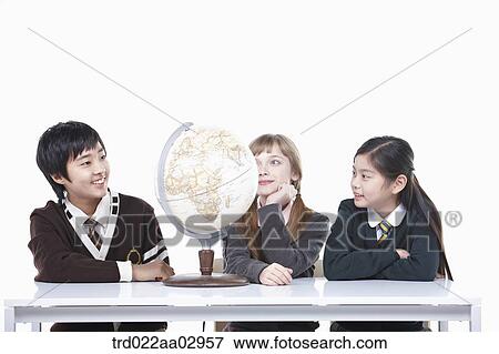 Stock Photo - The global students looking at the globe. Fotosearch