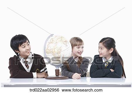 Stock Photograph - The global students looking at the globe. Fotosearch
