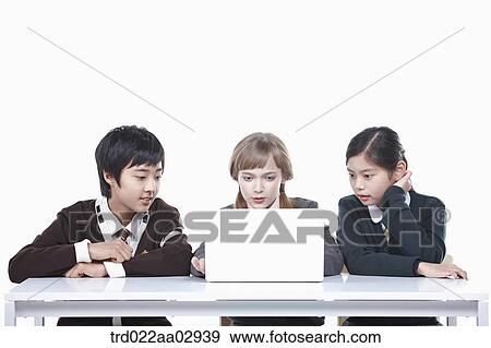 Stock Photo - The global students looking at the laptop . Fotosearch