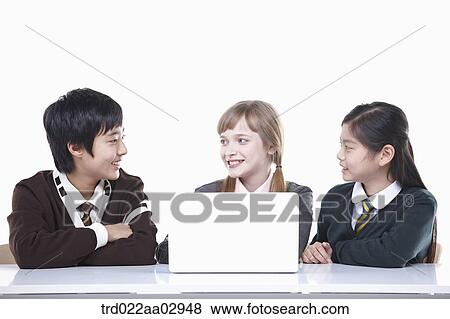 Stock Photo - The global students talking with the laptop around. Fotosearch