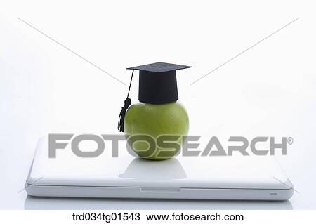 The graduation cap and apple on the laptop View Large Photo Image Stock Image - The graduation cap and apple on the laptop . Fotosearch