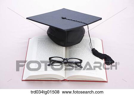 The graduation cap and glasses on the book View Large Photo Image Stock Photo - The graduation cap and glasses on the book. Fotosearch