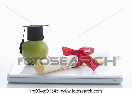 The graduation cap, apple, and diploma on the laptop View Large Photo Image Stock Photography - The graduation cap, apple, and diploma on the laptop . Fotosearch