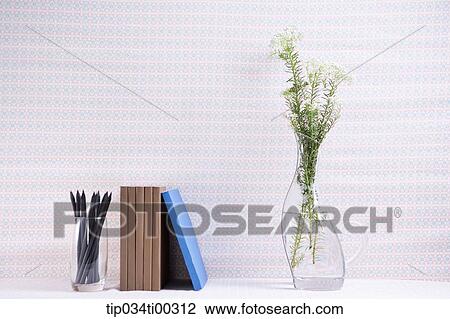 Stock Image - The pencil in glass, book, and flower in vase. Fotosearch