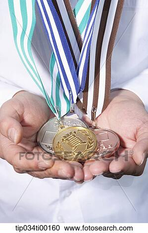 Stock Image - The prize medal on the hand. Fotosearch