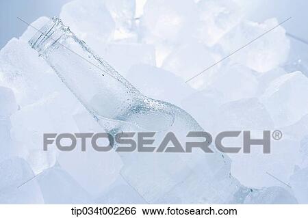 Stock Photograph - a bottle of water in the ice cubes. Fotosearch
