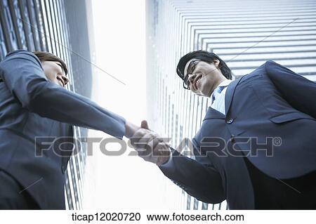 A business man shacking hands with a business woman View Large Photo Image Stock Image - A business man shacking hands with a business woman . Fotosearch