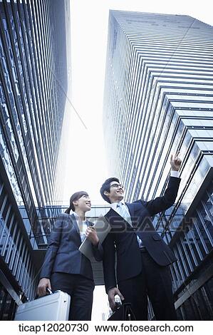 Stock Image - A business man watching in the direction the woman is pointing. Fotosearch
