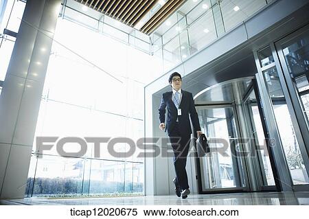 A business man with a briefcase man running into an office building View Large Photo Image Stock Photography - A business man with a briefcase man running into an office building . Fotosearch