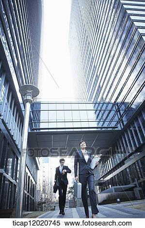 A business woman and a business man running between office buildings View Large Photo Image Stock Photography - A business woman and a business man running between office buildings . Fotosearch