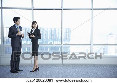 A business woman and a man standing next to long wide windows View Large Photo Image Stock Image - A business woman and a man standing next to long wide windows. Fotosearch