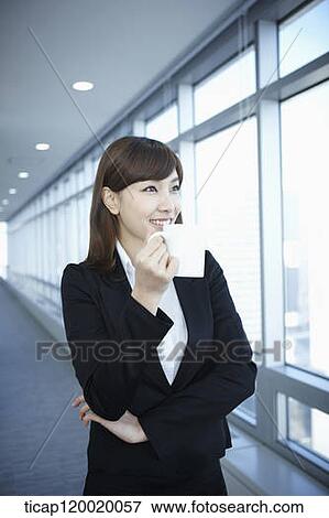 A business woman drinking a cup of coffee while looking out a window View Large Photo Image Stock Photo - A business woman drinking a cup of coffee while looking out a window. Fotosearch