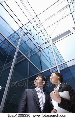 A businessman and woman in modern building View Large Photo Image Stock Image - A businessman and woman in modern building. Fotosearch