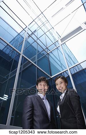 A businessman and woman standing in a modern building View Large Photo Image Stock Image - A businessman and woman standing in a modern building. Fotosearch