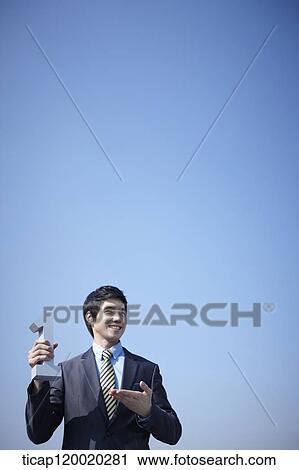 Stock Image - A businessman holding a number one block. Fotosearch