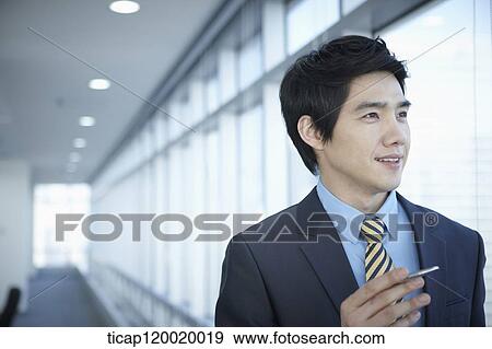 Stock Photo - A businessman holding a pen. Fotosearch