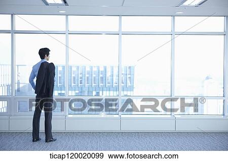 Stock Photo - A businessman holding a suit jacket on his shoulder. Fotosearch