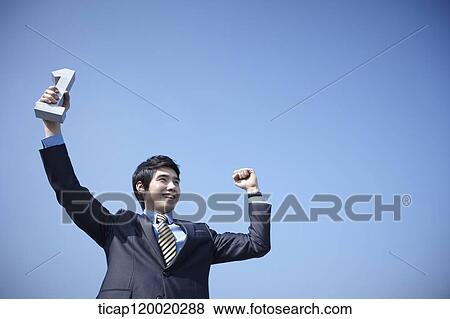 A businessman holding number block in his hand up high in the sky View Large Photo Image Stock Photo - A businessman holding number block in his hand up high in the sky. Fotosearch