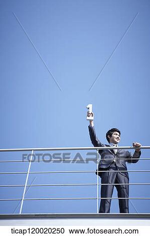 Stock Image - A businessman holding number one in one hand. Fotosearch