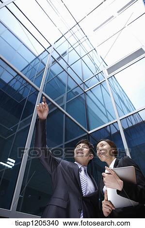 A businessman pointing while businesswoman holding a report View Large Photo Image Stock Image - A businessman pointing while businesswoman holding a report . Fotosearch