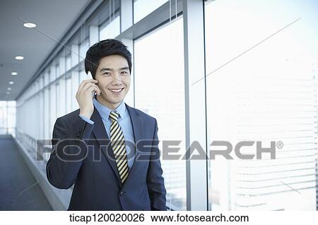 A businessman smiling while answering a phone View Large Photo Image Stock Photograph - A businessman smiling while answering a phone. Fotosearch