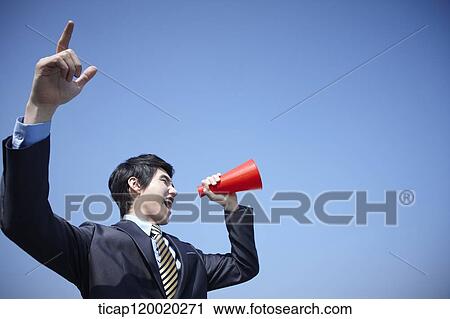 A businessman speaking with a megaphone while pointing up in the sky View Large Photo Image Stock Image - A businessman speaking with a megaphone while pointing up in the sky. Fotosearch