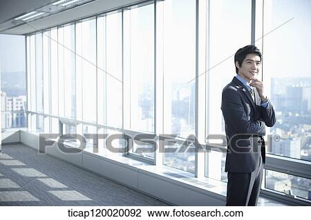 A businessman standing with a hand on his chin View Large Photo Image Stock Image - A businessman standing with a hand on his chin. Fotosearch