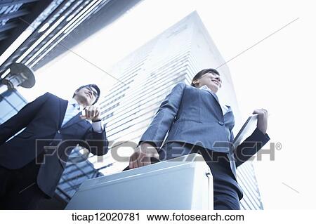A close up of a business woman and a business man between office buildings View Large Photo Image Stock Image - A close up of a business woman and a business man between office buildings . Fotosearch