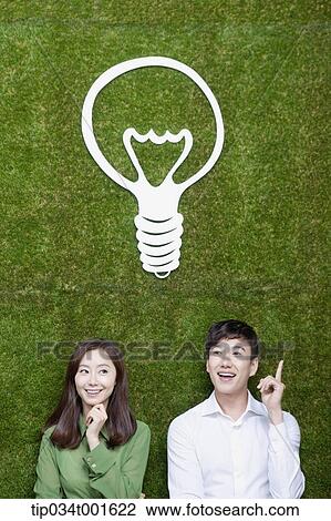 Stock Image - a couple coming up with idea together under the bulb. Fotosearch