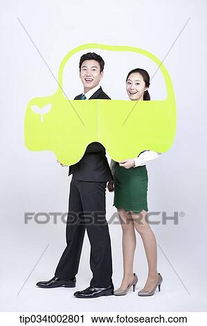 Stock Image - a couple holding a green paper car . Fotosearch