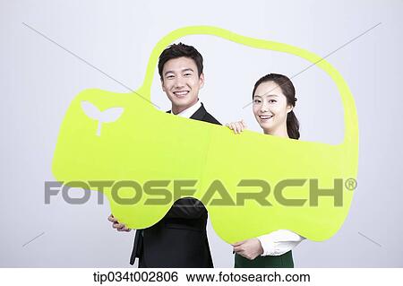 Stock Photograph - a couple holding a green paper car . Fotosearch