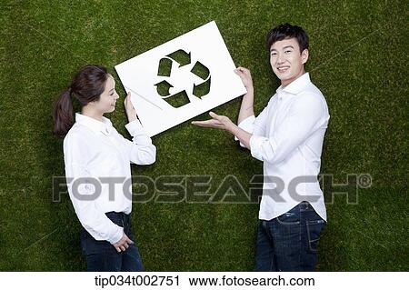 a couple holding a paper cut of recycling sign View Large Photo Image Stock Image - a couple holding a paper cut of recycling sign. Fotosearch