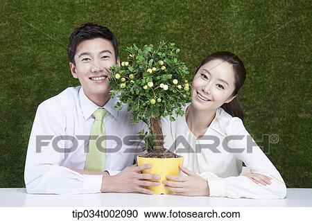 a couple holding tree pot in the table View Large Photo Image Stock Image - a couple holding tree pot in the table. Fotosearch