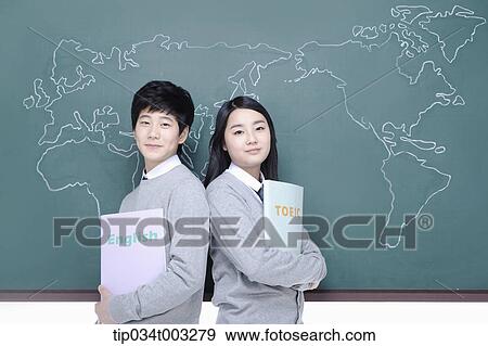 Stock Photo - a couple of students leaning against each other in front of the blackboard. Fotosearch