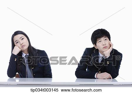 Stock Photography - a couple of students resting their chins on their hands. Fotosearch