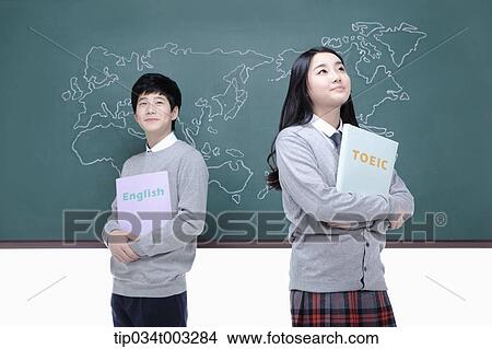a couple of students standing and with book in hands View Large Photo Image Picture - a couple of students standing and with book in hands. Fotosearch