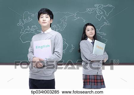a couple of students standing and with book in hands View Large Photo Image Stock Photography - a couple of students standing and with book in hands. Fotosearch