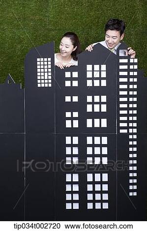 Stock Image - a couple standing behind the building model . Fotosearch