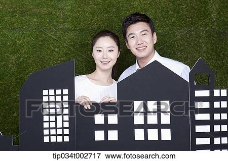 Stock Photo - a couple standing behind the building model . Fotosearch