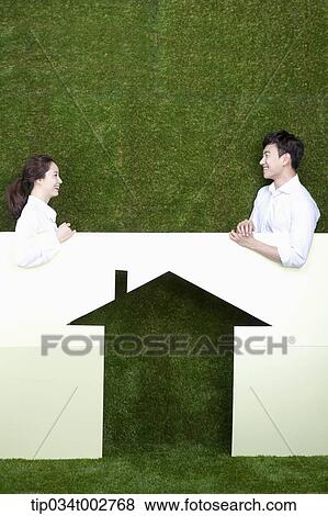 a couple standing behind the paper house View Large Photo Image Stock Photo - a couple standing behind the paper house. Fotosearch