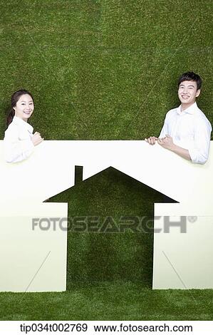 a couple standing behind the paper house View Large Photo Image Stock Photo - a couple standing behind the paper house. Fotosearch