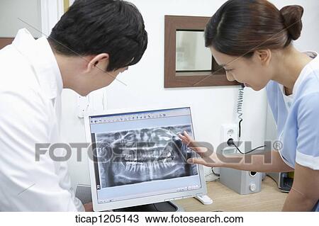 A dentist and a nurse watching teeth x-ray picture in a computer View Large Photo Image Stock Image - A dentist and a nurse watching teeth x-ray picture in a computer . Fotosearch
