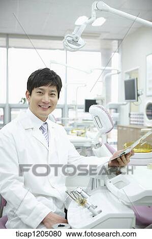 A dentist in dental treatment room View Large Photo Image Stock Image - A dentist in dental treatment room. Fotosearch